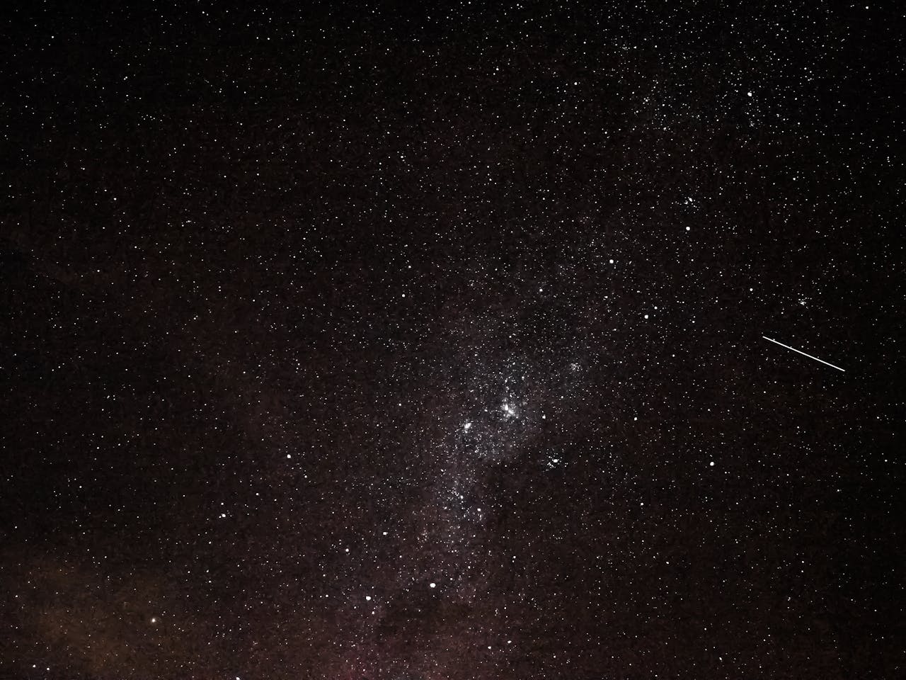 services-02 A breathtaking view of a star-filled sky with a visible shooting star.