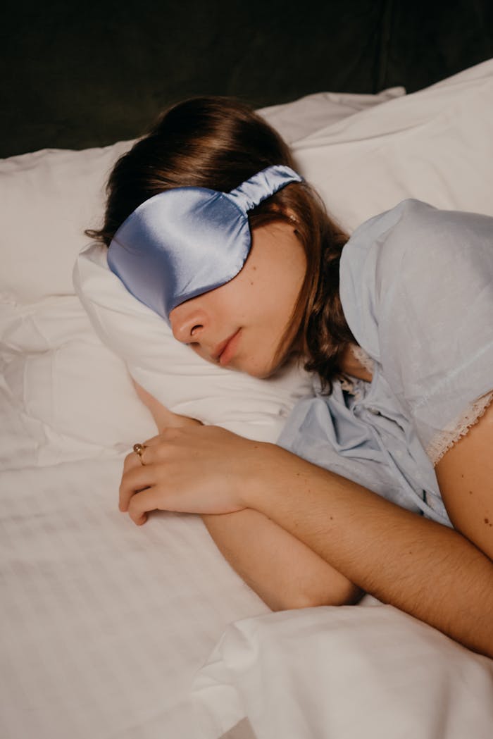 gallery-3 A woman peacefully sleeping with a satin eye mask, providing a sense of relaxation and comfort.